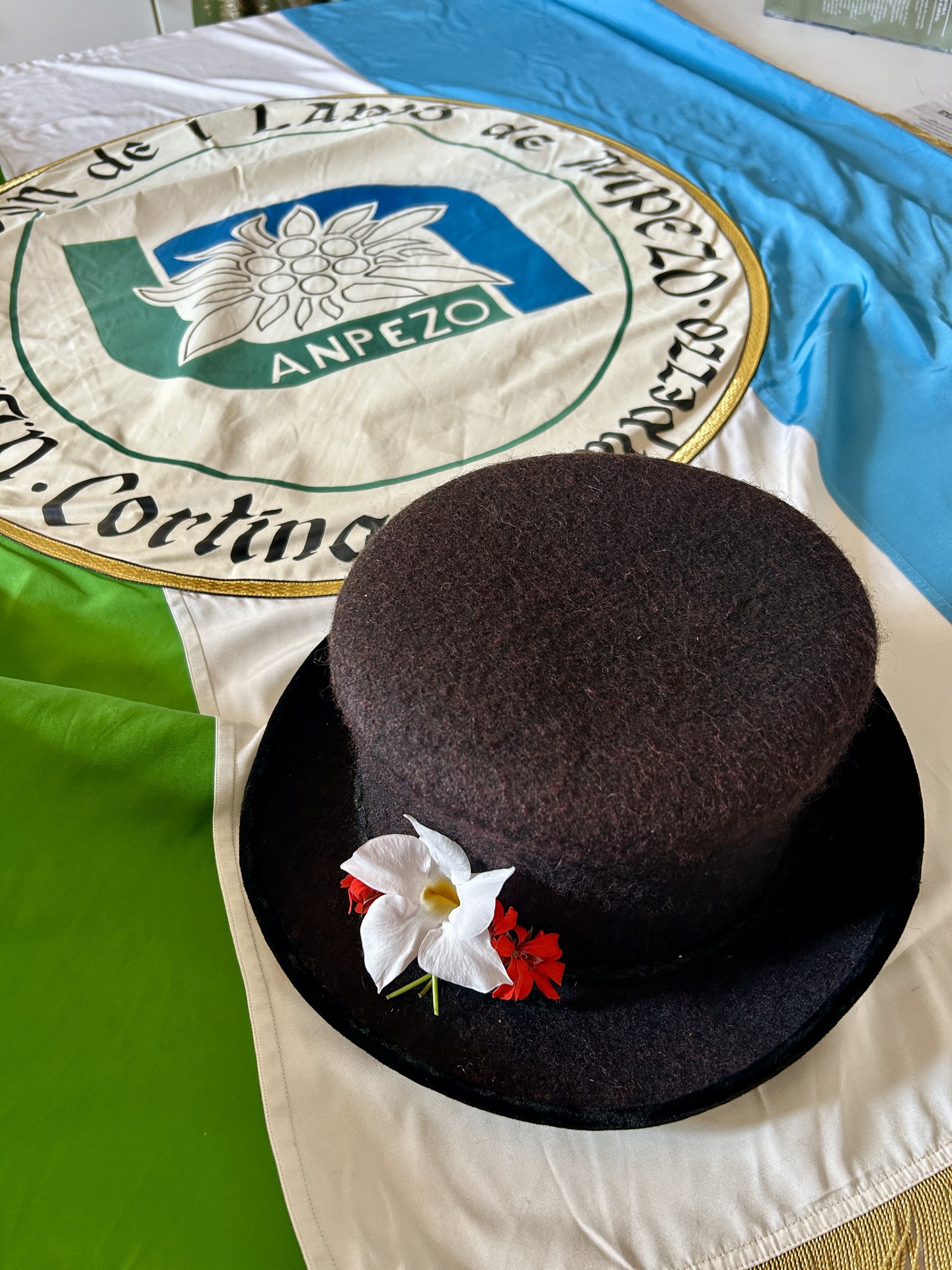 Ampezzano felt hat with flowers on the Union de i Ladis de Anpezo flag (IMG_3984.jpeg)